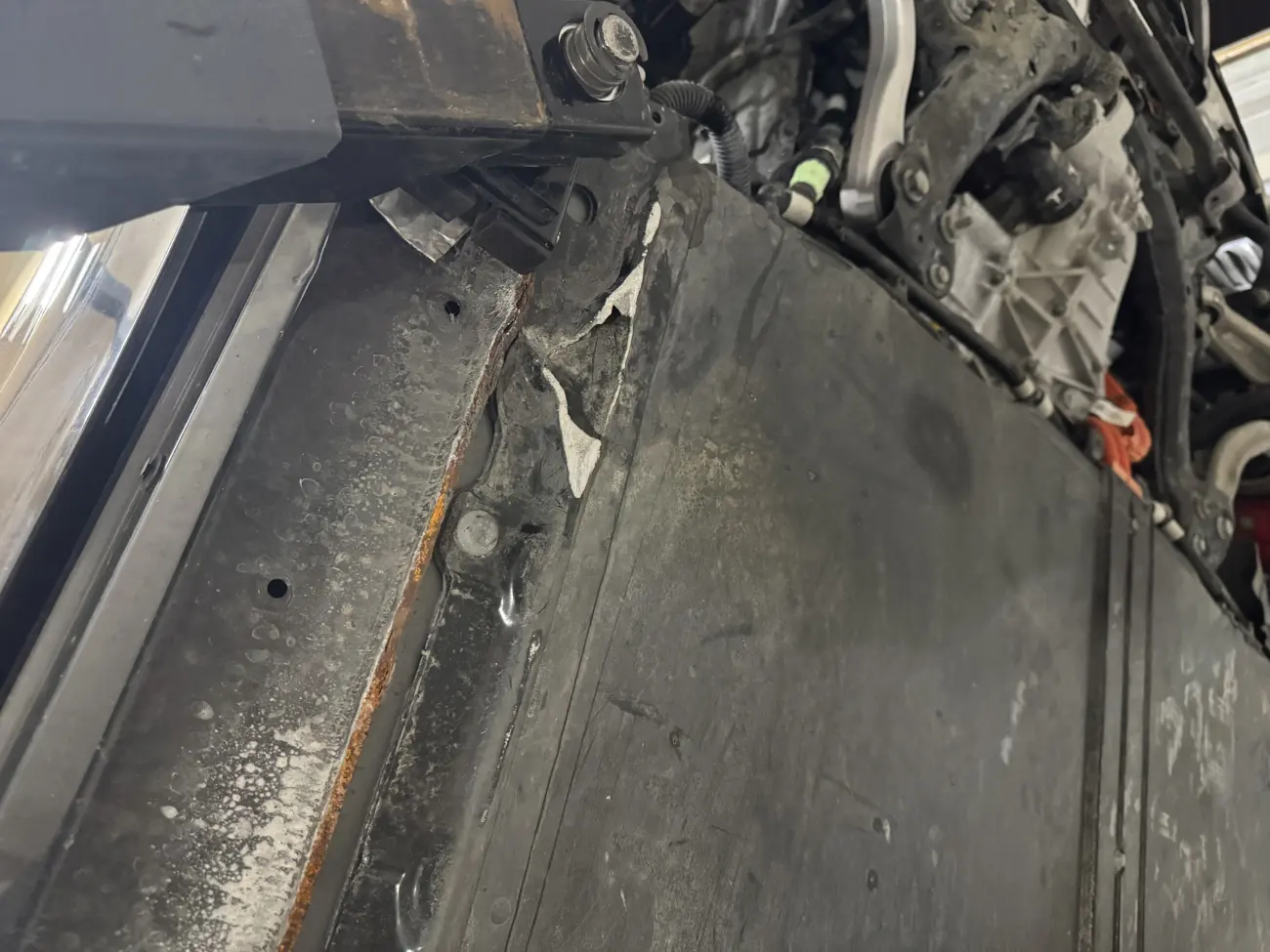 Tesla 高壓電池包外殼邊緣鏽蝕與接縫受損痕跡特寫